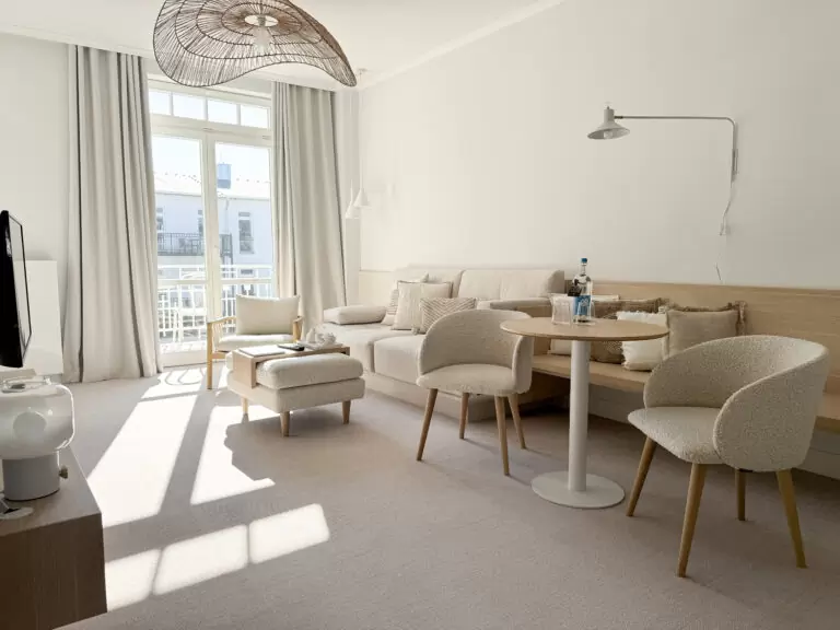 Helle, minimalistische Suite mit viel Tageslicht, Sofa und Sitzbereich – ein ruhiger Ort für Entschleunigung und Slow-Travel-Momente an der Ostsee