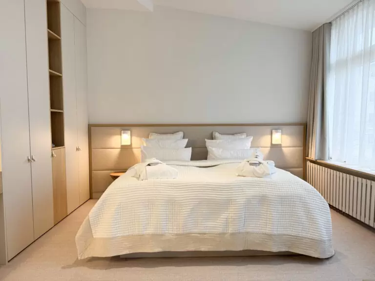 Ruhiges, warmes Schlafzimmer in einer Suite – ideal für Wellness im Winter und erholsame Auszeiten an der Ostsee.